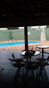 a patio with tables and chairs and a pool at Hotel Miracema Palace LTDA in Miracema do Norte