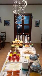 a table with many different types of food on it at Hotel Miracema Palace LTDA in Miracema do Norte