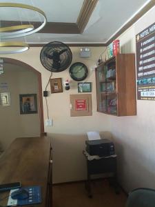 a room with a desk and a clock on the wall at Hotel Miracema Palace LTDA in Miracema do Norte