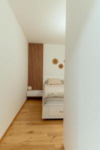 a bedroom with a bed and a wooden floor at Anur Apartment in Ptuj