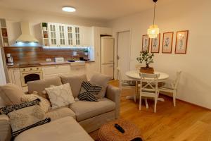 a living room and kitchen with a couch and a table at Anur Apartment in Ptuj