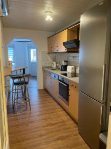 a kitchen with a stainless steel refrigerator and wooden floors at Zum Talblick in Limbach +12 photos