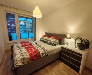 a bedroom with a bed and a window at Boho style apartment with garage and large terrace in Bratislava +20 photos