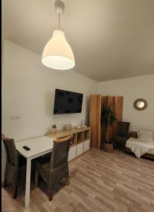 a living room with a table and chairs and a tv at Boho style apartment with garage and large terrace in Bratislava