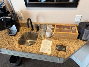 a kitchen counter with a sink and a tray of cups at Resort at Eagle Point Golf Club Lodging in Medford +96 photos