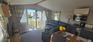 a living room with a blue couch and a sliding glass door at Graham's Dream in Heysham