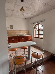 a kitchen with a table and four chairs at Casa La Ronda in Quito +7 photos