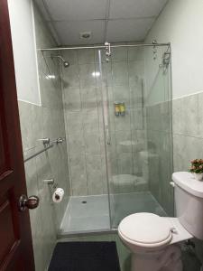 a bathroom with a glass shower with a toilet at Casa La Ronda in Quito