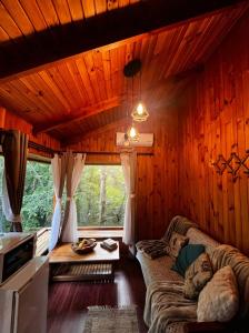a living room with a couch in a room with wooden walls at Hotel Termas de San Luis in Pucón