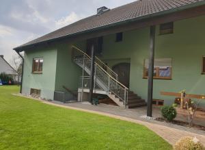 a green house with stairs on the side of it at Große Ferienwohnung nähe dem schönen Seenland in Merkendorf