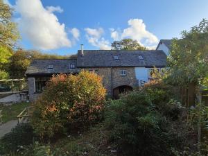 an old stone house with a garage at The Old Mill Annexe in Jacobstowe