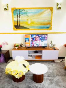 a living room with a tv and a table at Jnelis Home in Yaoundé