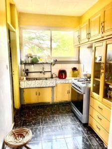 a kitchen with yellow cabinets and a sink and a window at Jnelis Home in Yaoundé