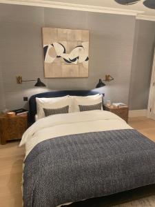 a bedroom with a bed and a painting on the wall at The Brompton Residence Hotel in London