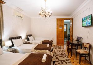 a hotel room with two beds and a chandelier at Ala's Old District in Kutaisi