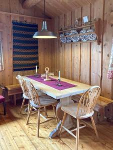 a dining room with a wooden table and chairs at Simple Mountain Cabin Near Vinstra in Vinstra