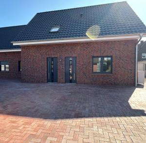a red brick house with a brick driveway at Kiefer in Nortrup