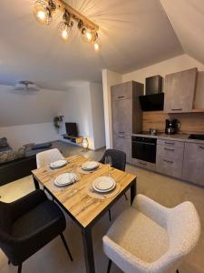 a dining room table with chairs and a kitchen at Kiefer in Nortrup