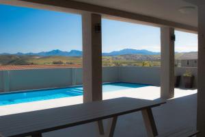 a balcony with a view of a swimming pool at 25 On Rooiels in Hartenbos