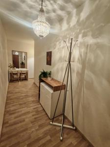 a room with a tripod and a table and a chandelier at Boho style apartment with garage and large terrace in Bratislava