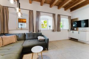 a living room with a couch and a tv at Gut Pecketsberg in Oepping