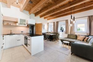 a kitchen and living room with a couch and a table at Gut Pecketsberg in Oepping