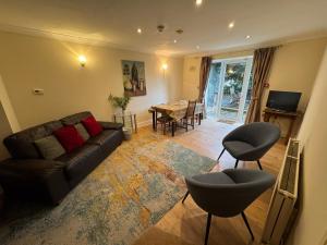 a living room with a couch and chairs and a table at Nether Edge Apartments in Sheffield