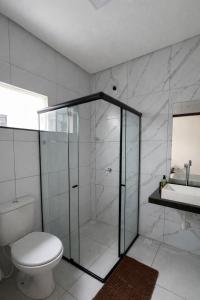 a bathroom with a shower and a toilet and a sink at Casa 3 Quartos Ar Condicionado , Area de Churrasco in Petrolina +22 photos
