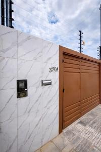 a garage door with a sign on the side of a building at Casa 3 Quartos Ar Condicionado , Area de Churrasco in Petrolina