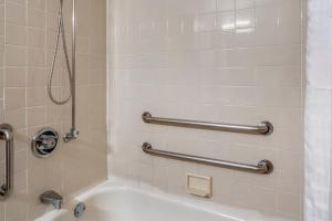 a bathroom with a tub and a shower with a sink at Red Roof Inn Queensbury in Queensbury +27 photos