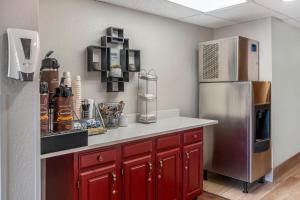 a kitchen with red cabinets and a refrigerator at Red Roof Inn Queensbury in Queensbury