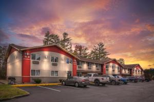 a building with cars parked in a parking lot at Red Roof Inn Queensbury in Queensbury