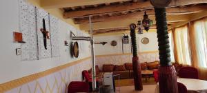 a room with a table and chairs and a room with a couch at Auberge IMIN TAGHYA in Akhendachou nʼAït Ouffi