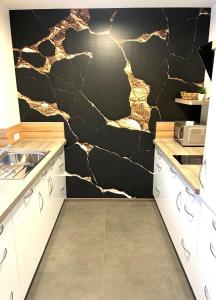 a kitchen with a black and gold stone wall at Haus Schloßbergblick in Leutschach
