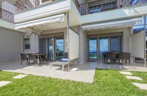 a patio with a table and chairs and a balcony at Panorama Dream Studios B in Vourvourou