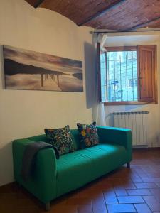 a green couch in a living room with a window at Lovely Stay in Sesto Fiorentino +2 photos