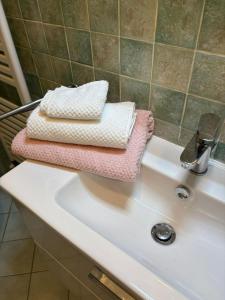 three towels sitting on top of a white sink at Lovely Stay in Sesto Fiorentino