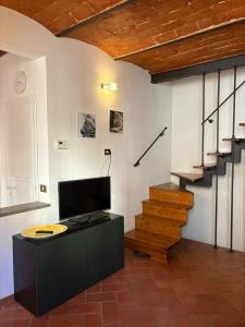 a living room with a tv and a staircase at Lovely Stay in Sesto Fiorentino