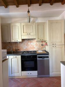 a kitchen with white cabinets and a black stove top oven at Lovely Stay in Sesto Fiorentino