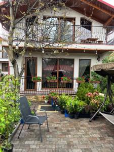 a chair sitting in front of a house with plants at U Slavika in Yasinya