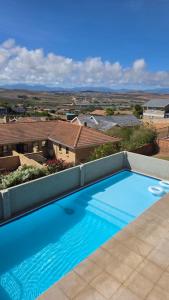a large blue swimming pool on top of a house at 25 On Rooiels in Hartenbos