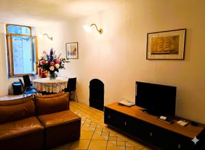 a living room with a couch and a table with a television at Riomaggiore Fisherman's House con Parcheggio vicino alla spiaggia in Riomaggiore