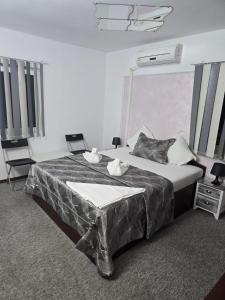 a bedroom with a large bed and two chairs at Pensiunea La Castel - Piscina incalzita in Costinesti +111 photos