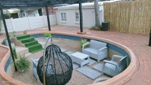 a backyard with a pool with two chairs and a couch at Palm Terrace Guesthouse in Durban