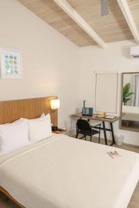 a bedroom with a bed and a desk and a table at Trade Winds Hotel Antigua in Dickenson Bay