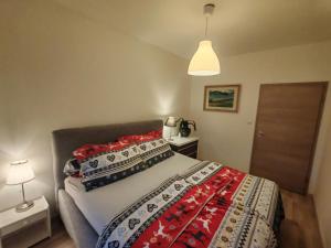 a bedroom with a bed with a red and white blanket at Boho style apartment with garage and large terrace in Bratislava