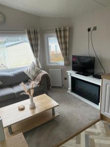 a living room with a couch and a flat screen tv at Westfield Lodge Retreat-Sleeps 6-Pet Friendly in Carnforth
