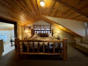 a bedroom with a large wooden bed in a attic at Riverfront Motel & Cabins in Thompson Falls
