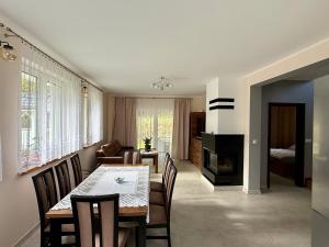 a dining room and living room with a table and chairs at Między Wzgórzami Korbielów in Korbielów