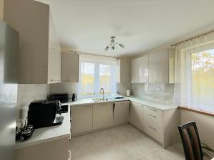 a kitchen with white cabinets and a sink at Między Wzgórzami Korbielów in Korbielów +6 photos